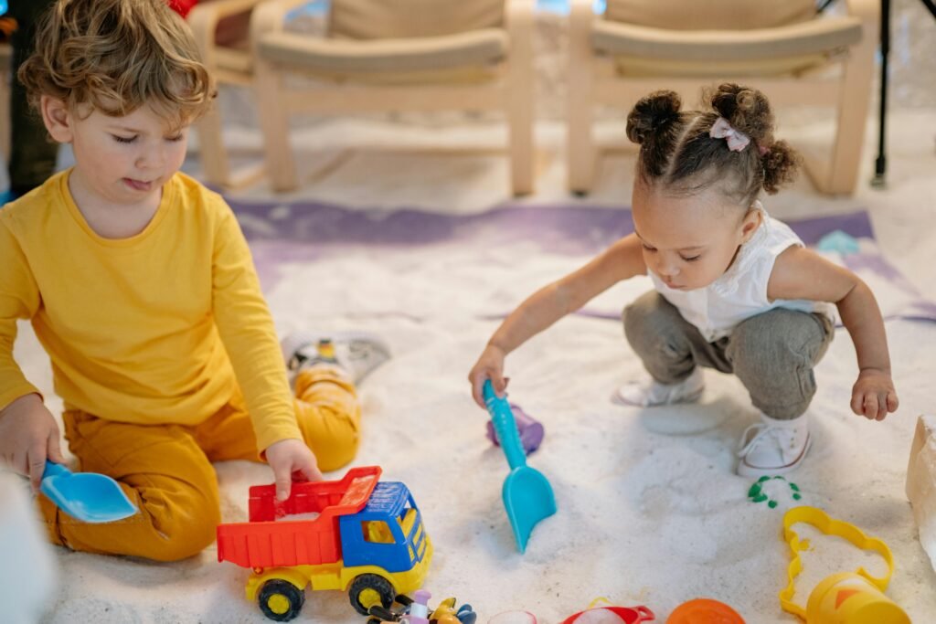 Junge und Mädchen spielen im Sand mit Sandspielzeug in der Wohnung
